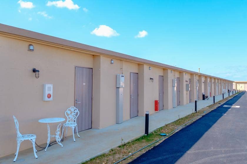 晴天の下に並ぶ複数の扉と、すっきりとした建物の外観