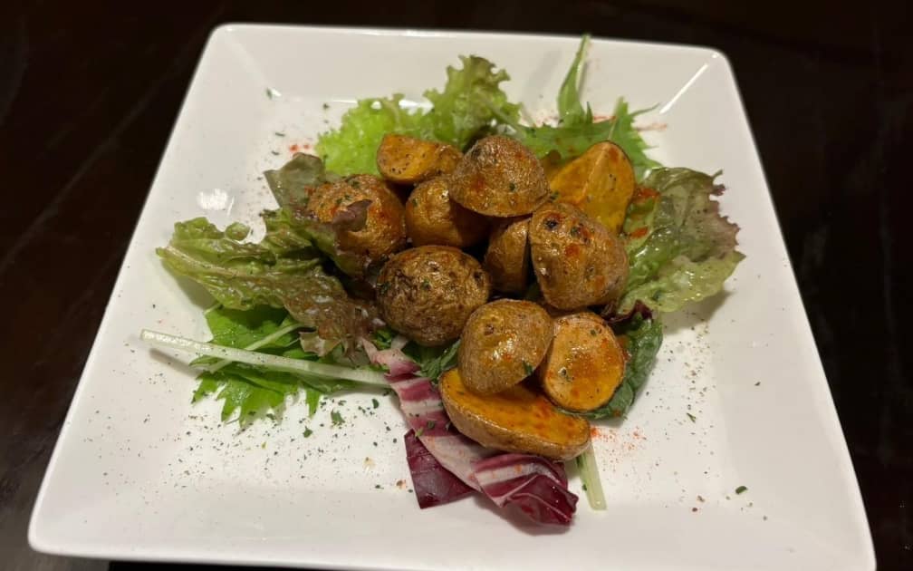 ローストポテトと新鮮な葉野菜が彩りを添える一皿