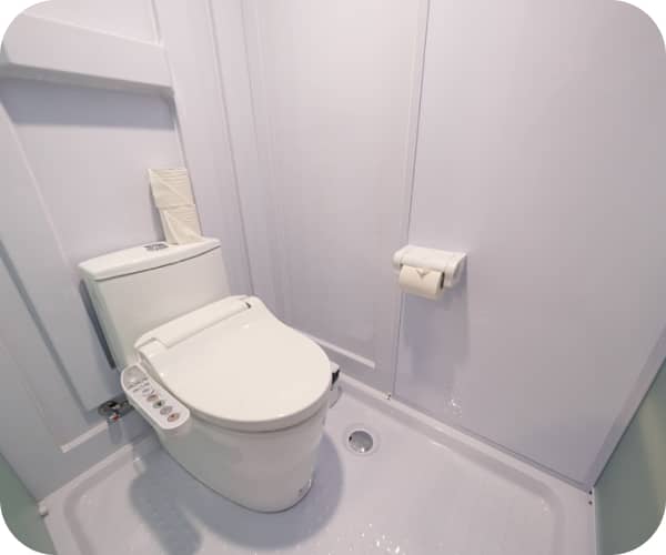 壁に取り付けられたトイレットペーパーホルダーが見える清潔なトイレ