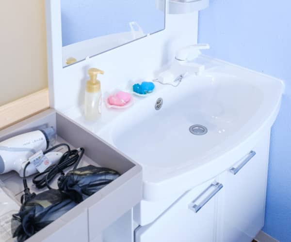 スタイリッシュでモダンな白い洗面台とその周辺の収納設備