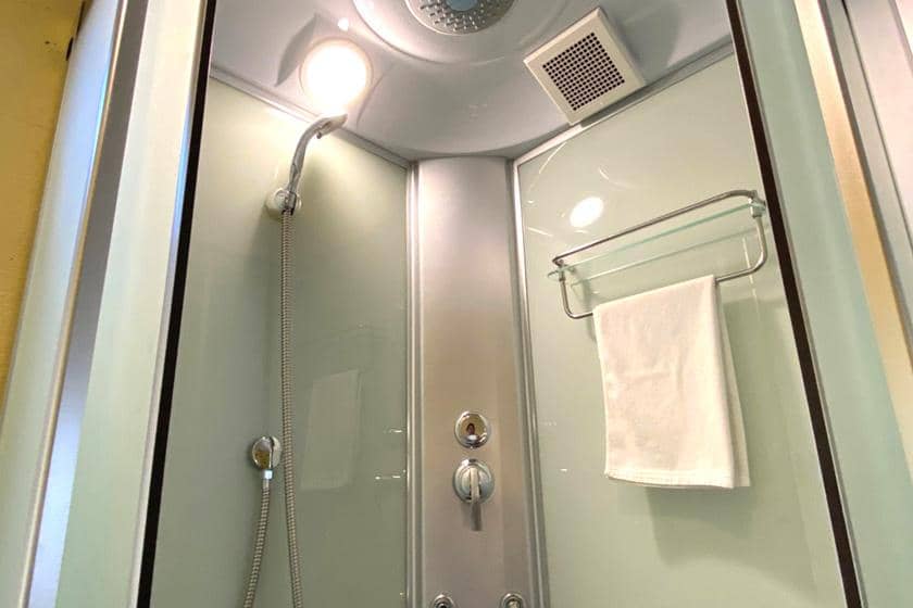 壁面に取り付けられたシャワー設備とタオルハンガー