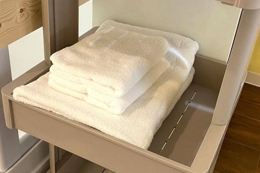 滞在用に用意された清潔な白いタオルがトレーに整頓されている
